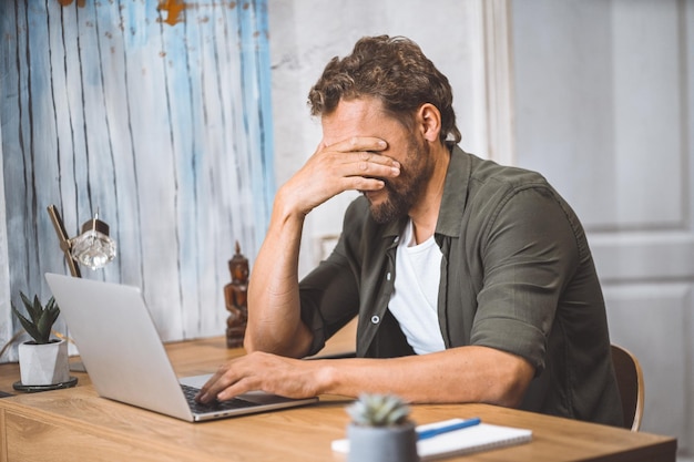 joven, utilizar, computador portatil, en el escritorio, en, oficina