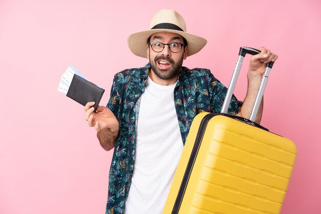 Joven en vacaciones con maleta y pasaporte y sorprendido