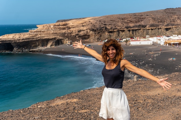 Una joven de vacaciones en la playa de Ajuy, Pájara, costa oeste de la isla de Fuerteventura, Islas Canarias. España