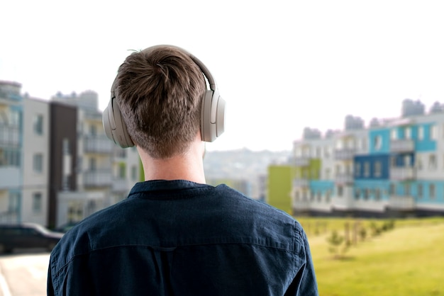 Un joven varón escucha auriculares, disfruta del audio, relájate y relájate