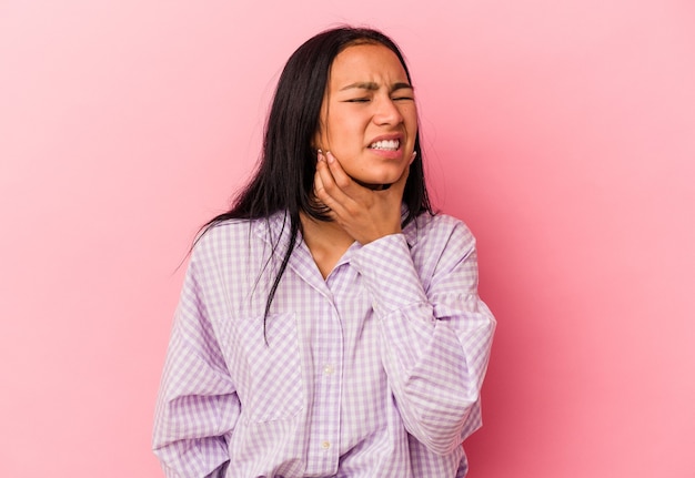 Joven venezolana aislada sobre fondo rosa con un fuerte dolor de dientes, dolor de muelas.