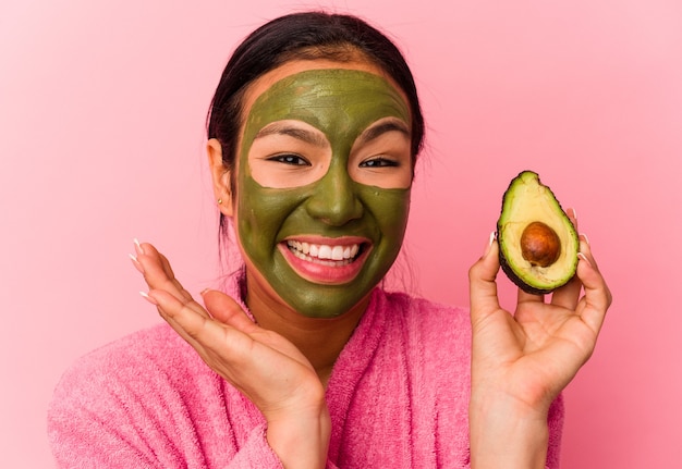 Joven venezolana con una máscara facial aislada sobre fondo rosa