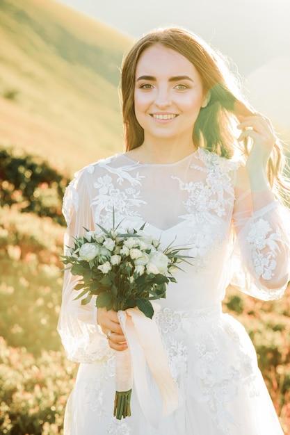 una joven con un vestido de novia camina por las montañas al amanecer por la mañana