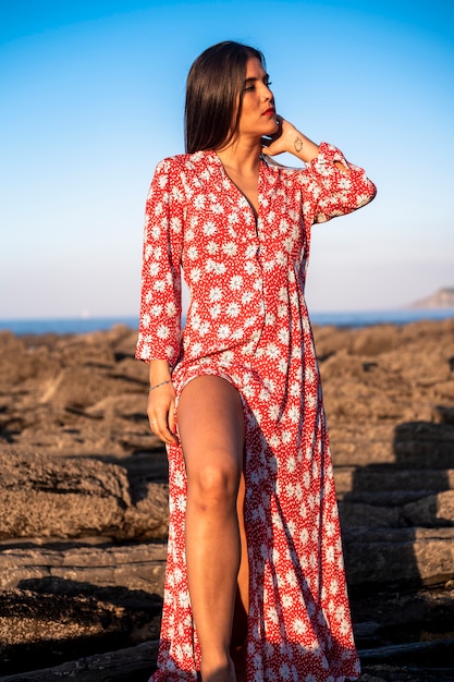 un joven con un vestido rojo largo afuera