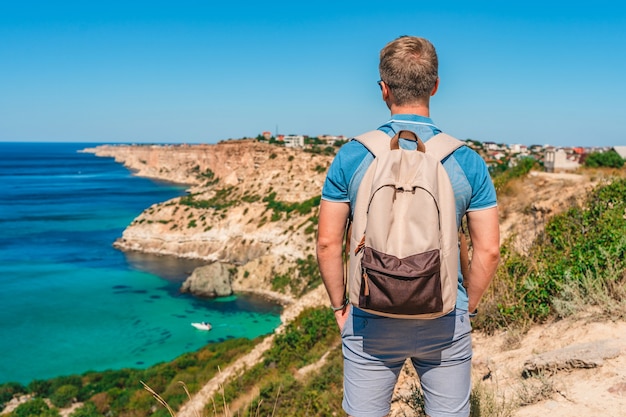 Un joven viaja a Cape Fiolent, el lugar más famoso de Crimea con olas azules y rocas.