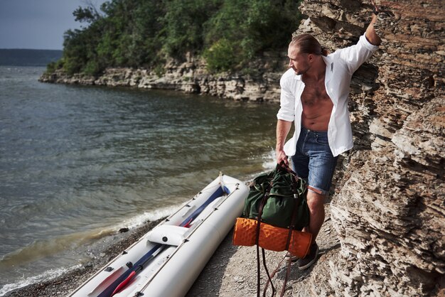 Un joven viaja con una mochila en un bote. La forma de vida de los viajes y la naturaleza con la naturaleza.