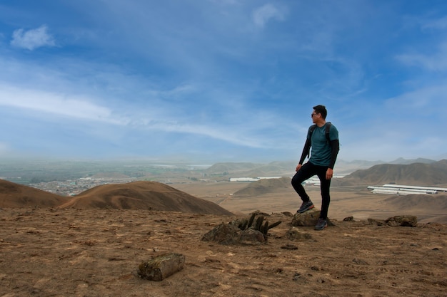 Joven de viaje observando el horizonte y un cielo impresionante