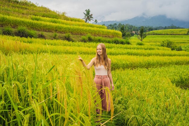 Joven viajera en las hermosas terrazas de arroz de Jatiluwih en el contexto de los famosos volcanes en Bali, Indonesia.