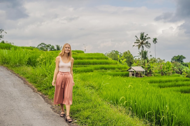 Joven viajera en las hermosas terrazas de arroz de Jatiluwih en el contexto de los famosos volcanes en Bali, Indonesia.