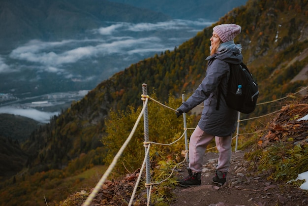 Joven viajera de senderismo en las montañas en otoño disfruta de la vista de la naturaleza