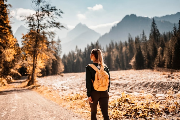 Joven viajero chica de senderismo con mochilas Senderismo en la naturaleza Estado de ánimo al atardecer Paisaje soleado Bielovodska walley eslovaquia Altos tatras