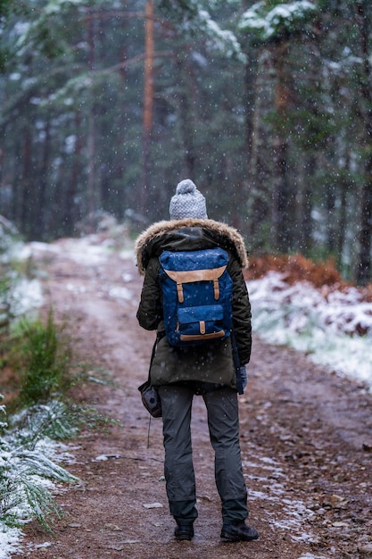 Foto un joven viajero con equipo de montaña captura un paisaje pintoresco de invierno con su cámara