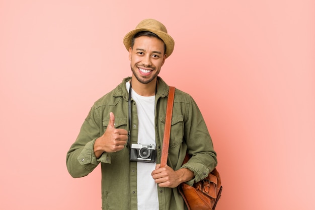 Joven viajero filipino hombre sonriendo y levantando el pulgar hacia arriba