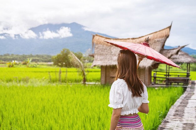 Joven viajero mirando y relajándose con hermoso campo de arroz verde