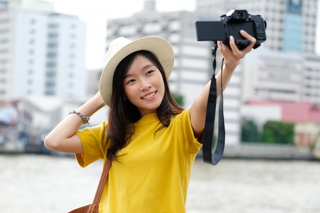 Joven viajero mujer asiática tomando selfie foto en la ciudad al aire libre