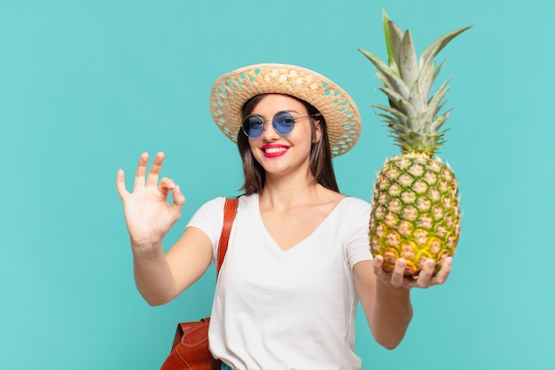 Joven viajero mujer feliz expresión y sosteniendo una piña