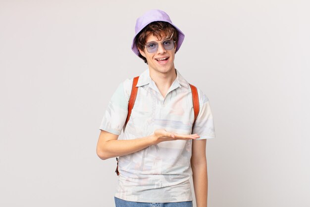 Joven viajero o turista sonriendo alegremente, sintiéndose feliz y mostrando un concepto