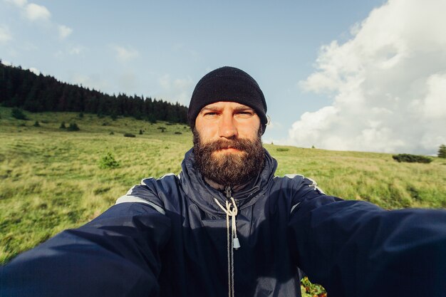 Joven viajero toma selfie en cordillera