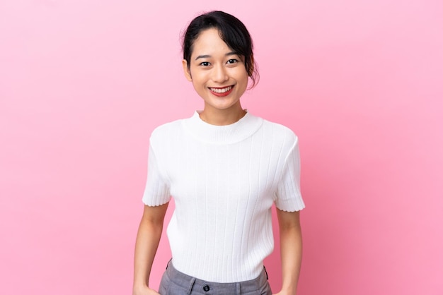 Joven vietnamita aislada sobre fondo rosa riendo