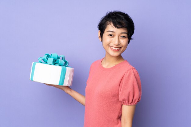 Joven vietnamita con el pelo corto con un gran pastel