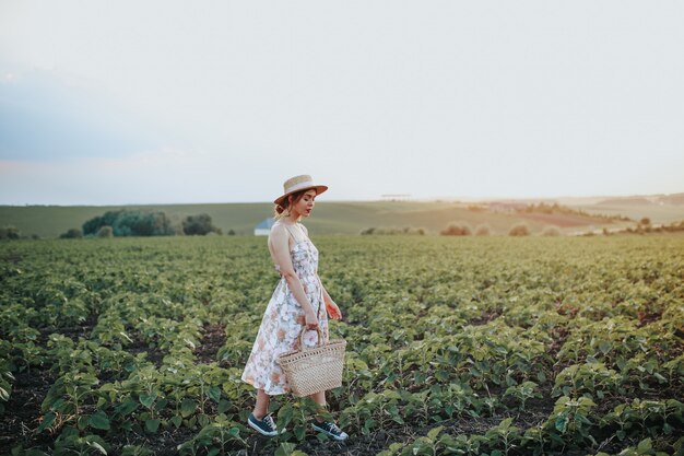 Joven vintage con un sombrero mientras mira el paisaje