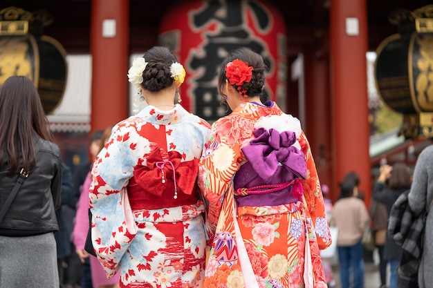 Joven vistiendo kimono japonés de pie delante del templo Sensoji en Tokio, Japón.