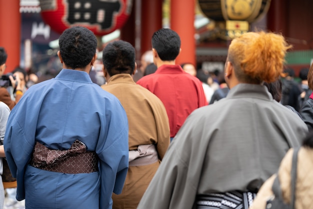 Joven vistiendo kimono japonés de pie delante del templo Sensoji en Tokio, Japón.