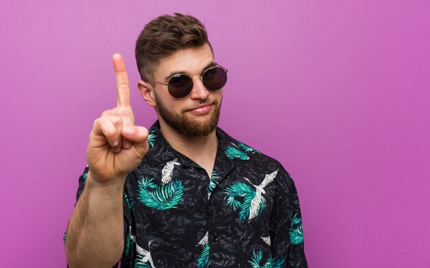 Joven vistiendo un look de vacaciones mostrando el número uno con el dedo