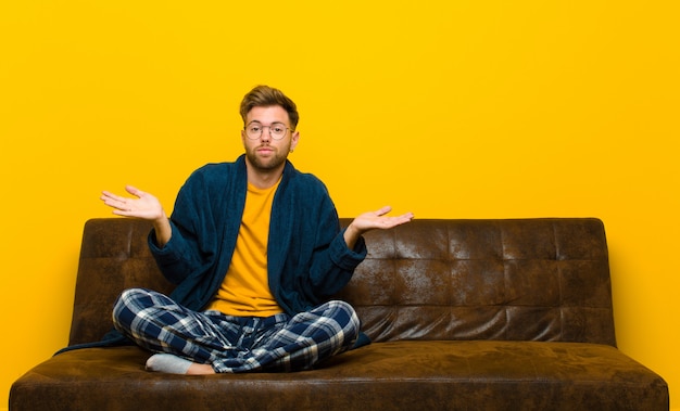 Joven vistiendo pijama sintiéndose perplejo y confundido