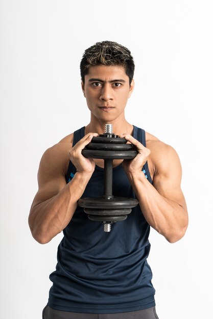 Foto joven vistiendo ropa de gimnasia levantar la pesa con ambas manos