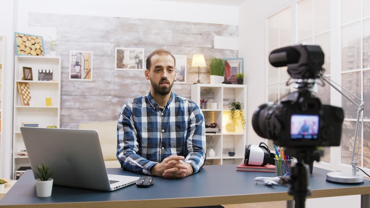 Foto joven vlogger hablando con sus suscriptores en las redes sociales. hombre creativo y famoso.