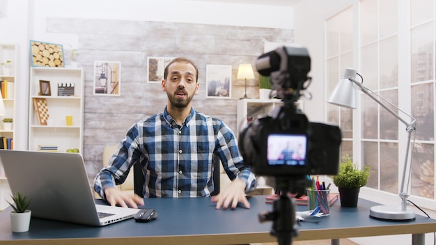 Joven vlogger hablando con sus suscriptores en las redes sociales. Hombre creativo y famoso.