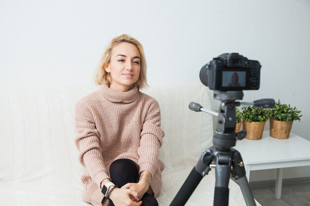 Joven vlogger junto a la cámara de vídeo en casa