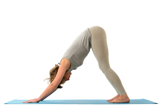 Foto joven yoga mujer en la posición adho mukha svanasana (perro). aislado en la pared blanca