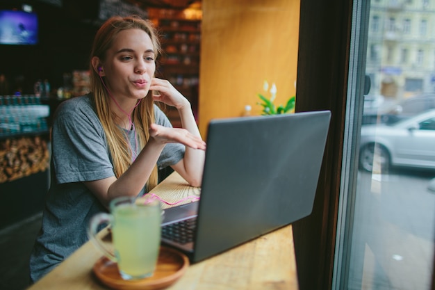 Foto una jovencita en un café se obsesiona en skype con su amada y le da un beso