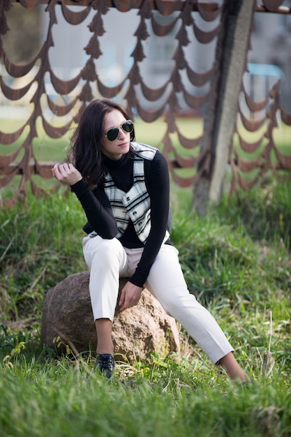 Jovencita con chaqueta celular y gafas de sol negras