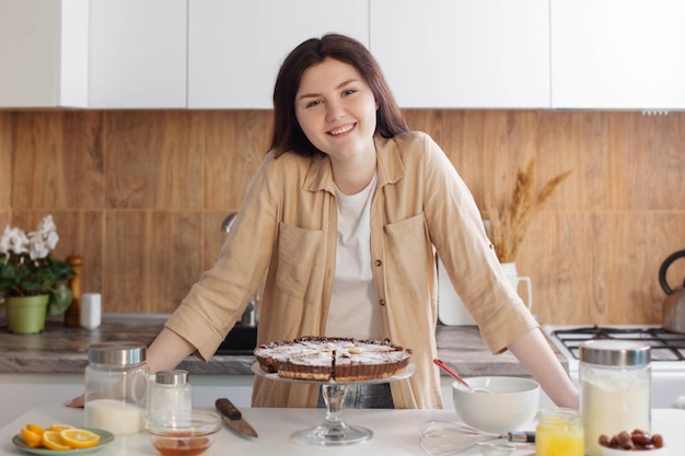 Jovencita cocinando pastel de nueces en la cocina