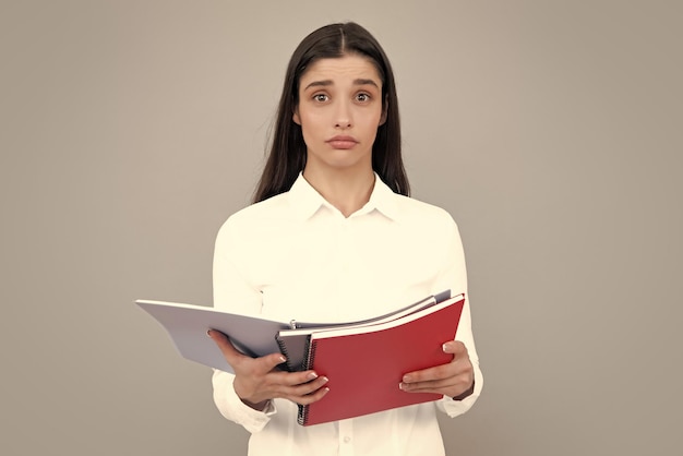 Jovencita con cuadernos de pie sobre fondo gris con espacio de copia Escuela de concepto educativo