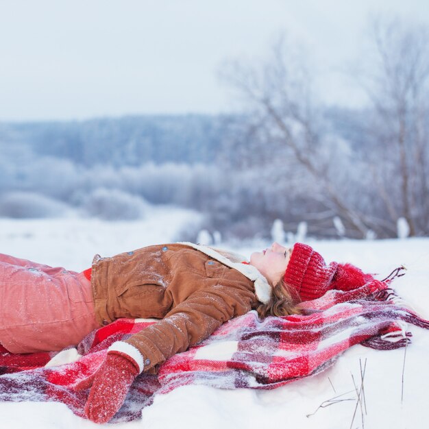 Jovencita en cuadros en la nieve