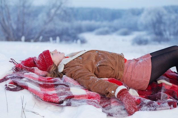 Jovencita en cuadros en la nieve