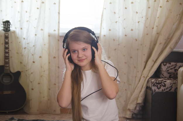 Jovencita escuchando música en auriculares en casa, pasatiempo juvenil