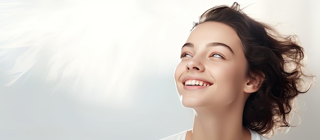 Jovencita mirando hacia arriba con una sonrisa copia espacio en blanco sobre fondo claro