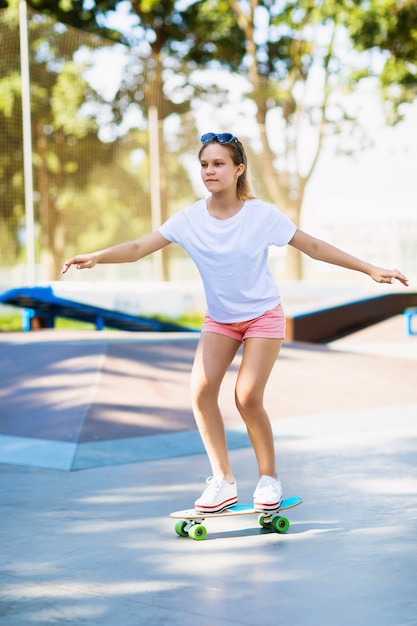 Jovencita monta una patineta en el parque