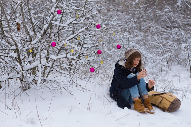 Jovencita en un paseo de invierno en un día de nieve Navidad