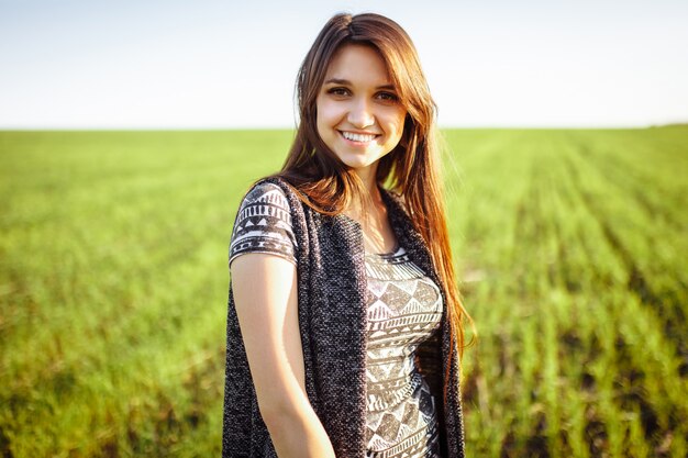 Una jovencita posando en el campo, mirando a la otra mitad