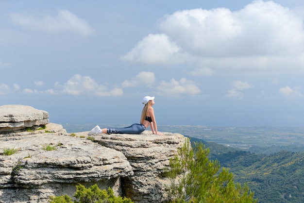 Jovencita practicando yoga en las montañas