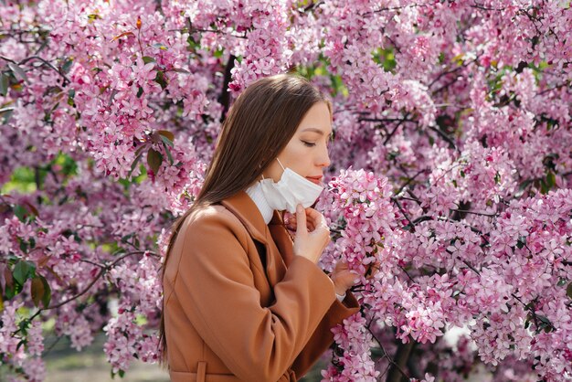 jovencita se quita la máscara y respira profundamente después del final de la pandemia en un soleado día de primavera