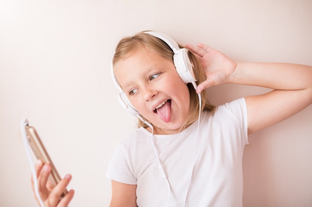 Jovencita rubia con auriculares escuchando música