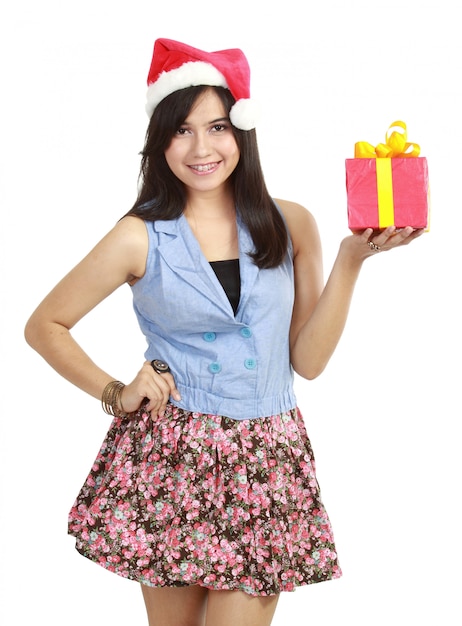 Jovencita con sombrero de Santa presentando regalo