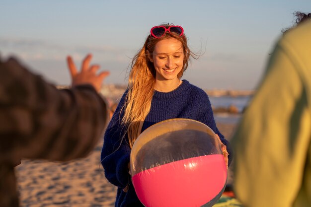 Jovencita sosteniendo una pelota de playa, en unas vacaciones de verano en Venice Beach, Los Ángeles